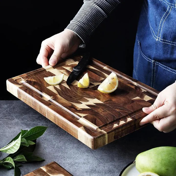 Brown solid acacia wood cutting board with 3cm thickness on a kitchen counter.