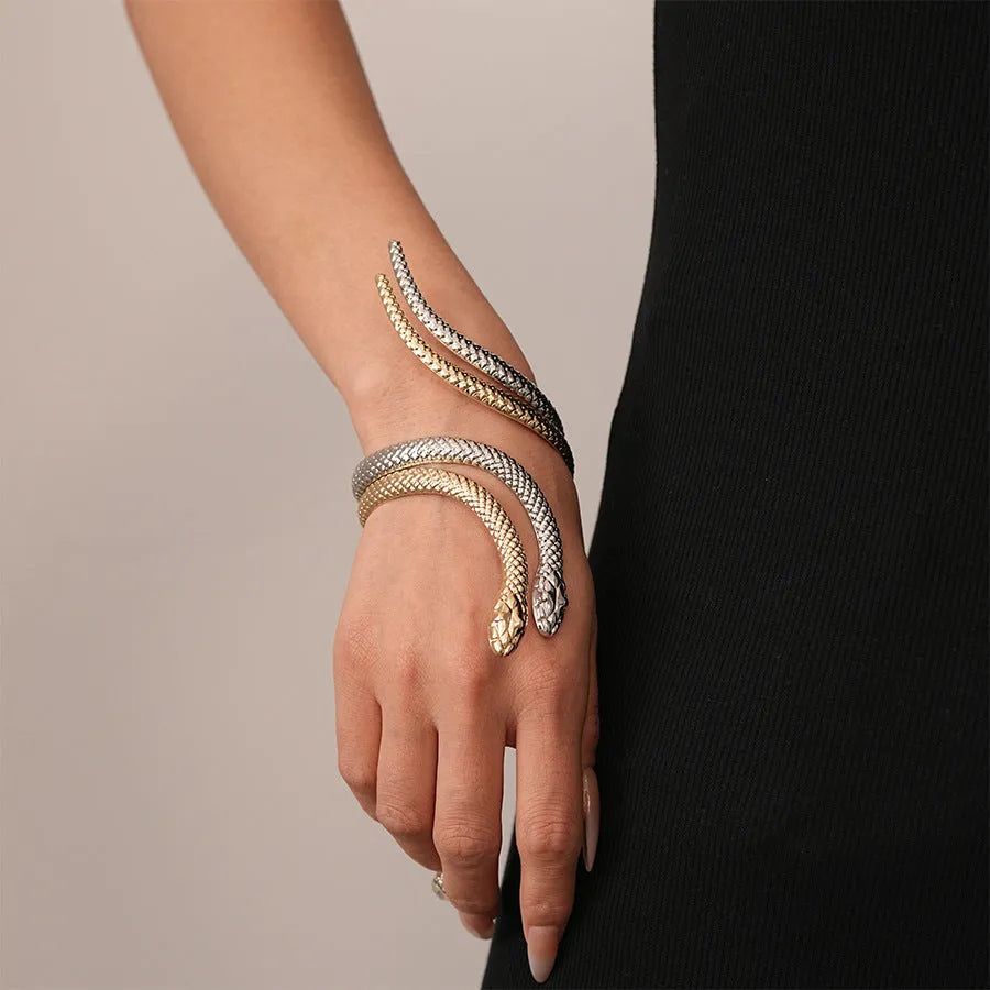Gold twisted snake design metal bracelet and ring set on a white background.