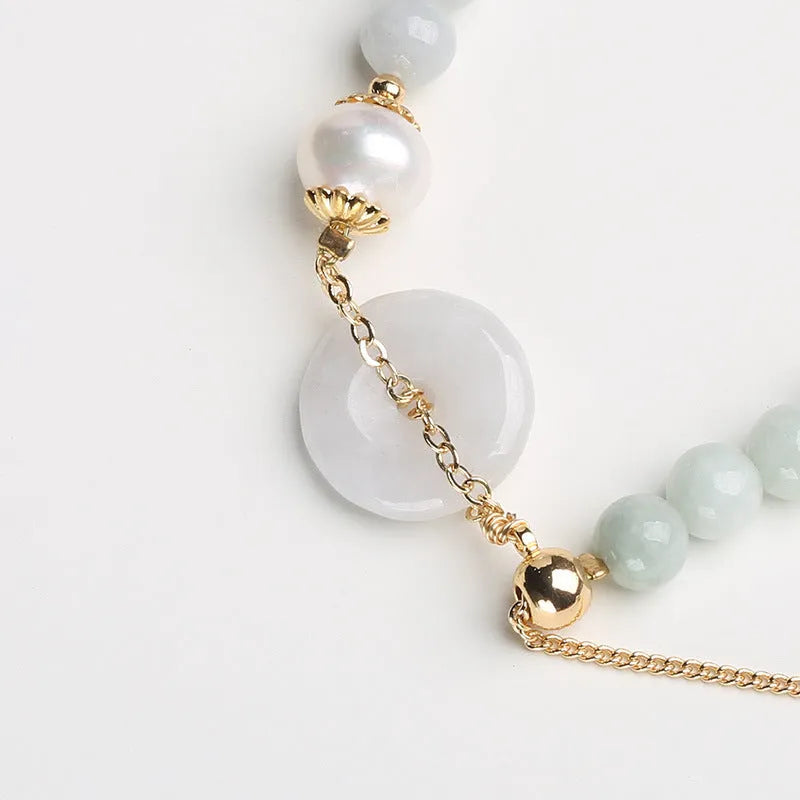 Jade green pearl bracelet with geometric pendant and peace buckle clasp on wrist