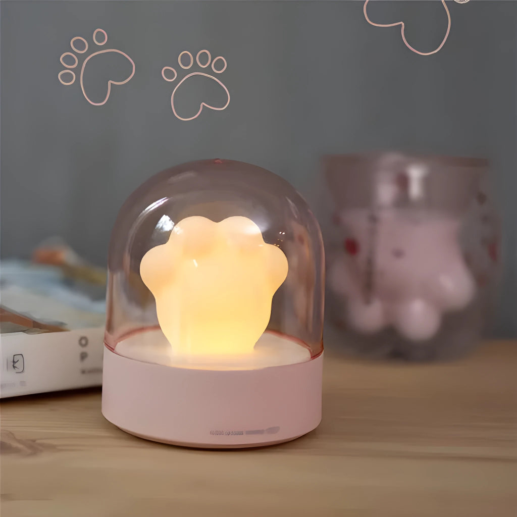 Grey and pink cat paw shaped USB rechargeable night light with adjustable brightness on a desk.