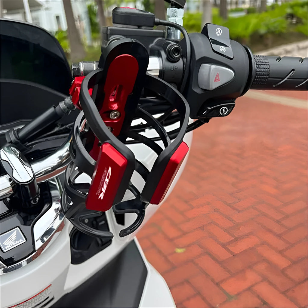 Black water bottle cage mounted on Honda X-ADV scooter bumper with mounting bracket visible