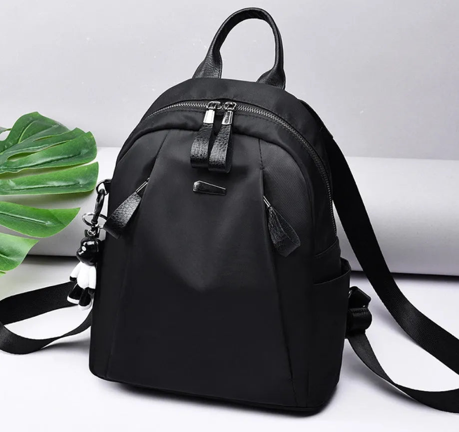 Medium-sized Oxford cloth rucksack in wine red, showing dual straps and external pocket.