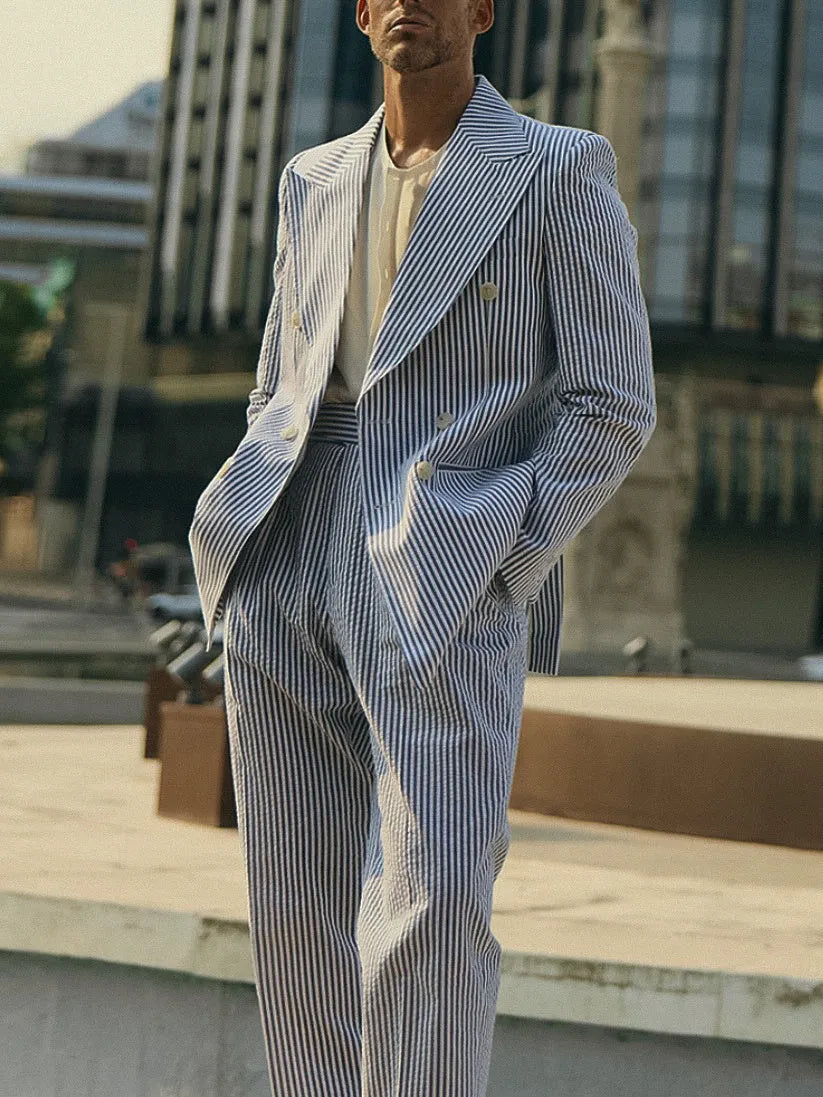 Blue and white striped polyester suit set with blazer and trousers on a hanger.