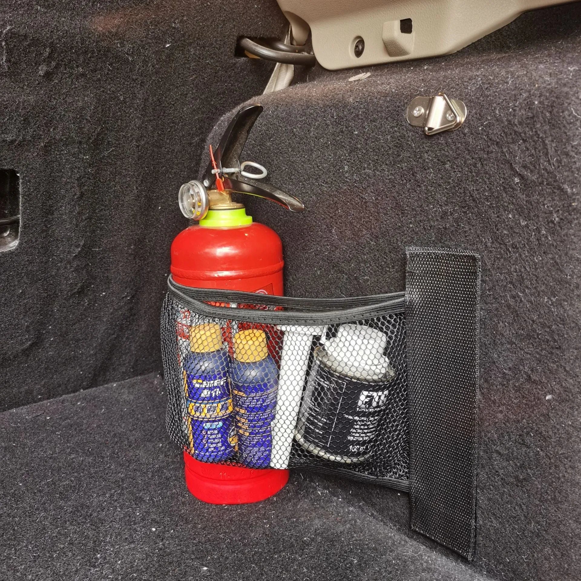 Black elastic polyester storage net for car boot organisation with hook-and-loop fasteners.