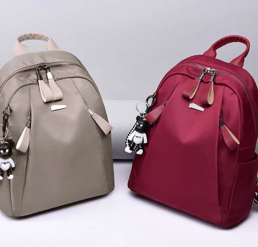 Medium-sized Oxford cloth rucksack in wine red, showing dual straps and external pocket.