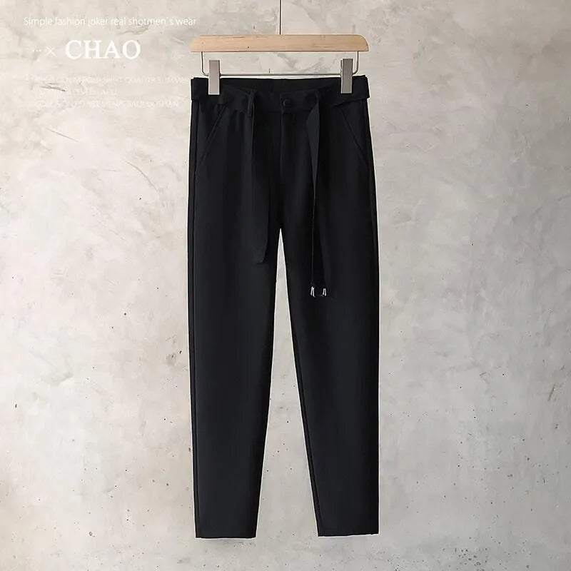 Boys slim straight-leg wool trousers in tapered cut, shown in black, on a hanger.