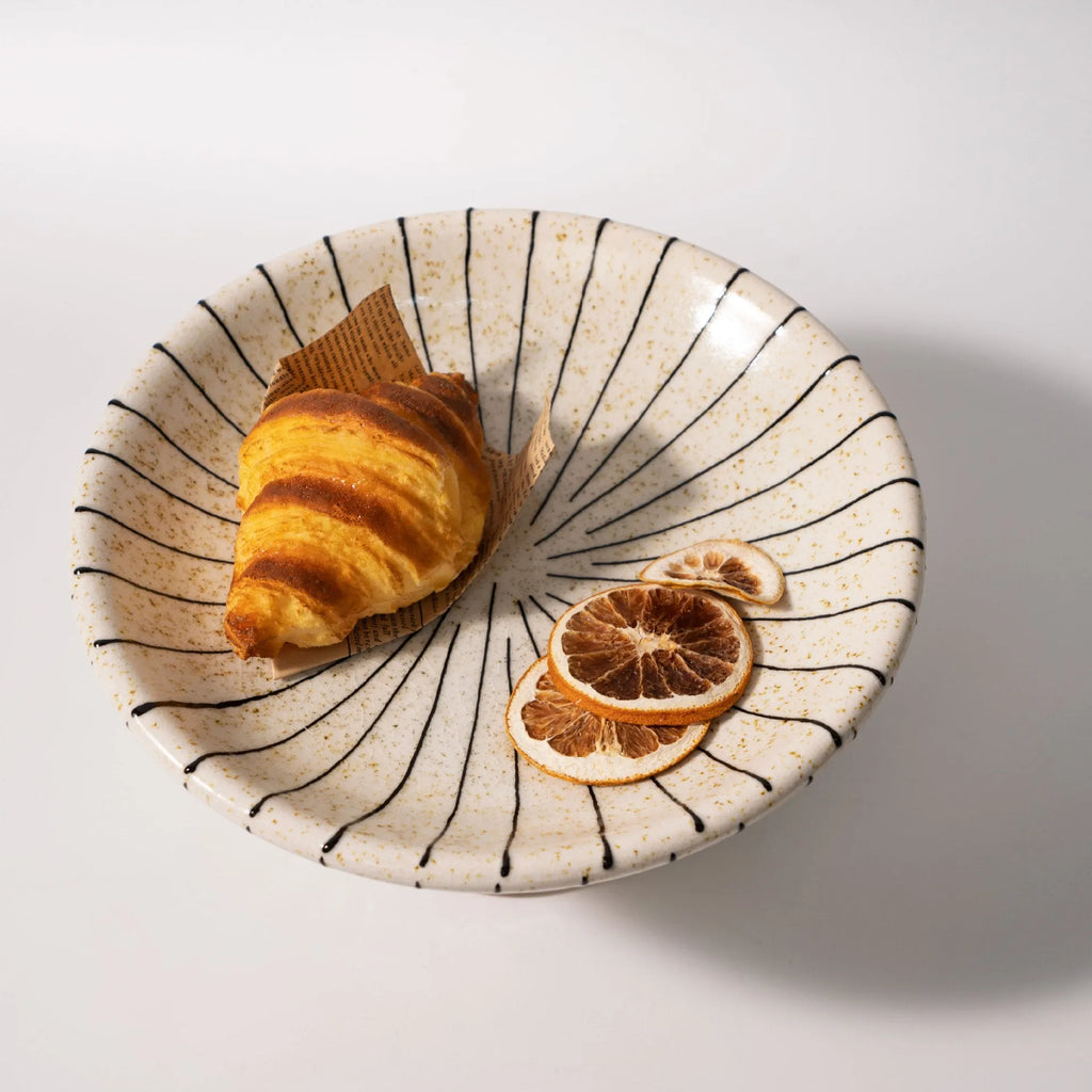 Black and white striped retro synthetic resin dessert plate on a table.