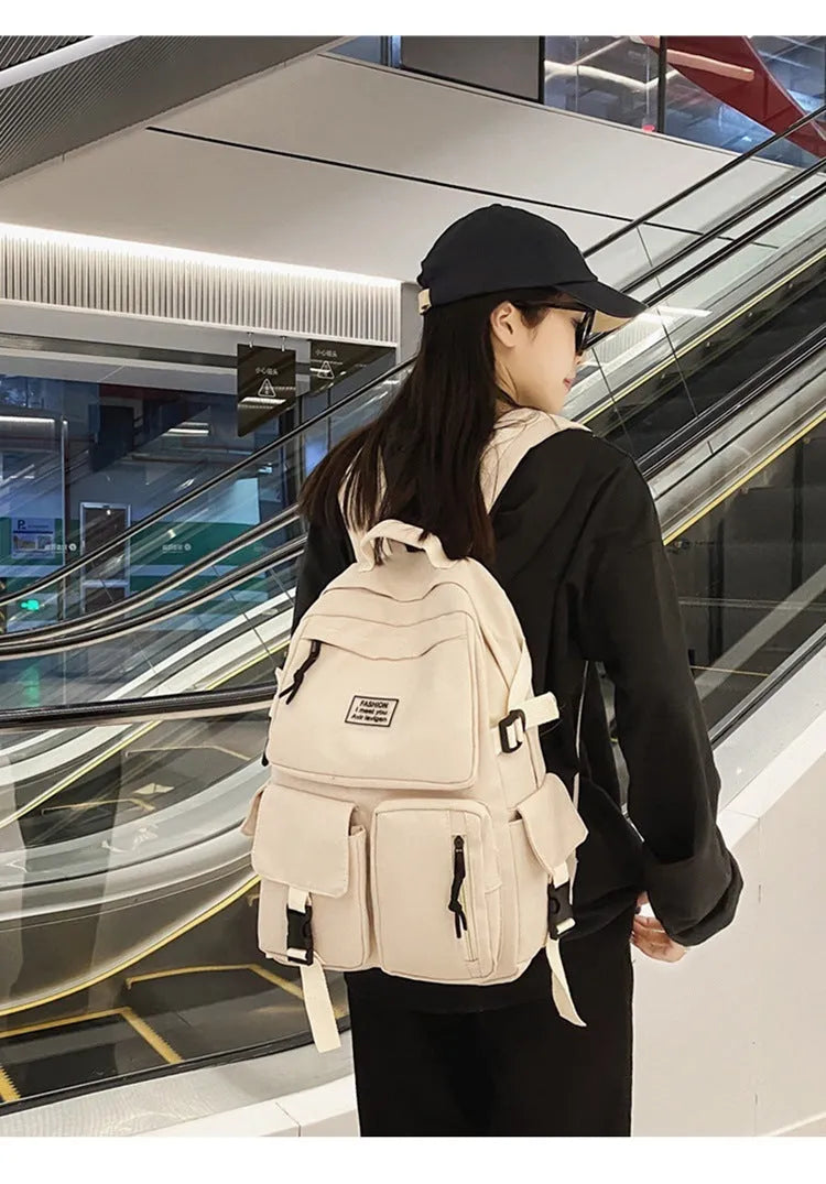 Black and white nylon student backpack with laptop compartment, showing three-dimensional pocket.