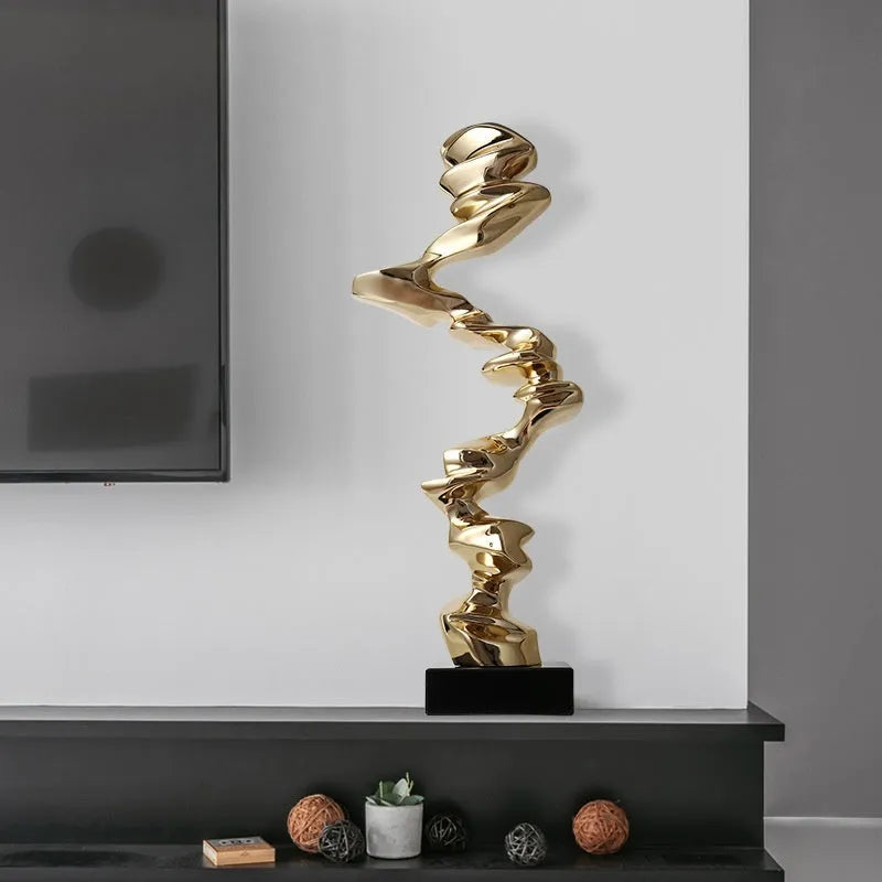 Modern abstract still life ornament in natural resin, shown in bright gold, elegant silver, and phantom blue finishes.