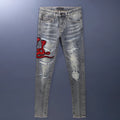Men's slim fit jeans in old colour with distressed holes and embroidered patches on the legs.