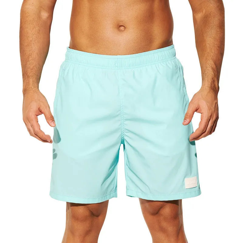 Men's solid colour quick-drying nylon beach shorts on a hanger, showing straight leg opening.