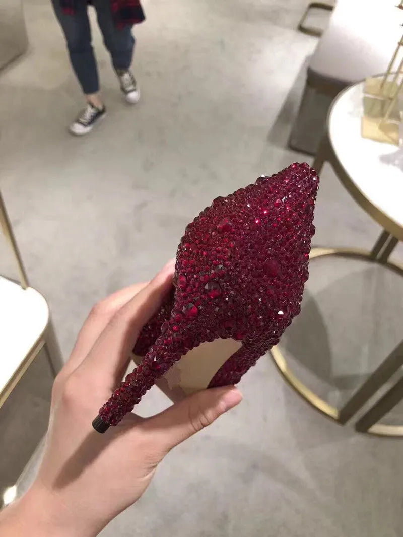 Women's gold pointed toe stiletto heels decorated with rhinestones and a bow