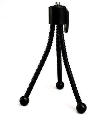 Small black iron mini tripod with ball head, shown extended next to a smartphone for scale.