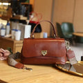 Women's brown leather saddle handbag with open outer pocket and double shoulder straps