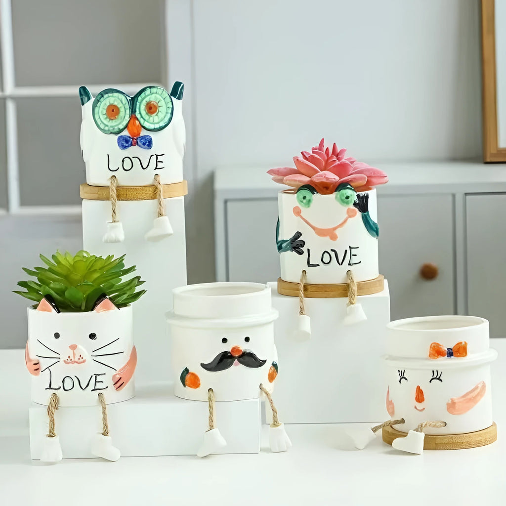 Ceramic cartoon-style hanging foot flowerpot for succulent plants on a desktop.