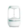 White anti-gravity humidifier on a table showing floating water droplets above its tank.