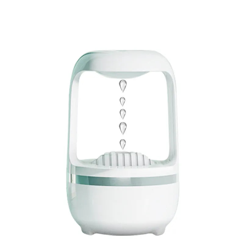 White anti-gravity humidifier on a table showing floating water droplets above its tank.