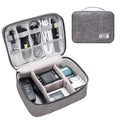 Black travel cable organiser bag open to show mesh pockets, elastic loops, and removable padded dividers inside.