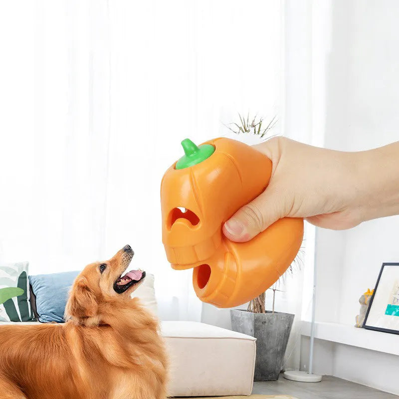 Orange Halloween pumpkin shaped interactive dog chew toy with treat-dispensing funnel.