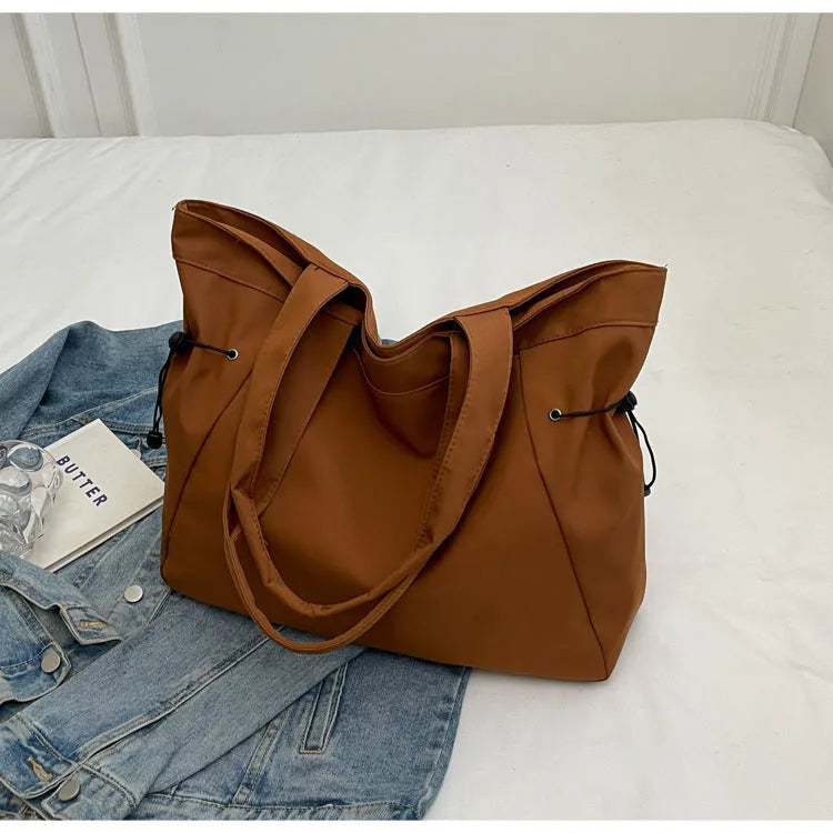 Soft Oxford cloth foldable tote bag shown in one of five colours: black, brown, dark grey, light grey, or purple.