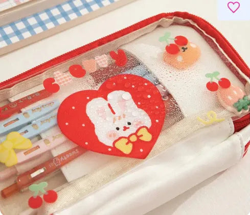 Transparent pen case with Japanese girl and heart graphic in pink or red colour options.