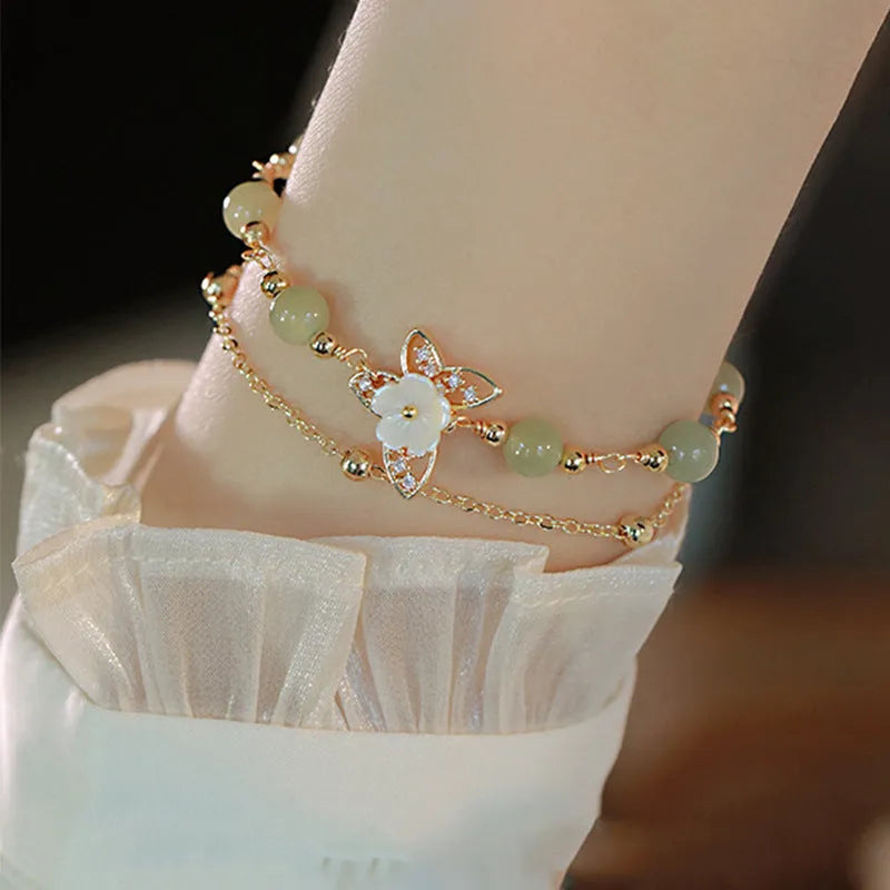 Yellow gold butterfly bracelet on copper base with geometric shape.