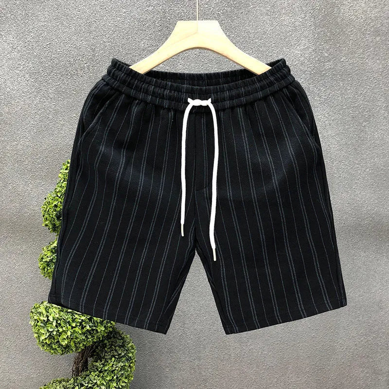 Men's black and white striped casual shorts with elastic waistband showing straight-leg design