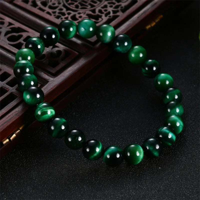 Green polished Tiger Eye stone bracelet with geometry beads on a wrist.