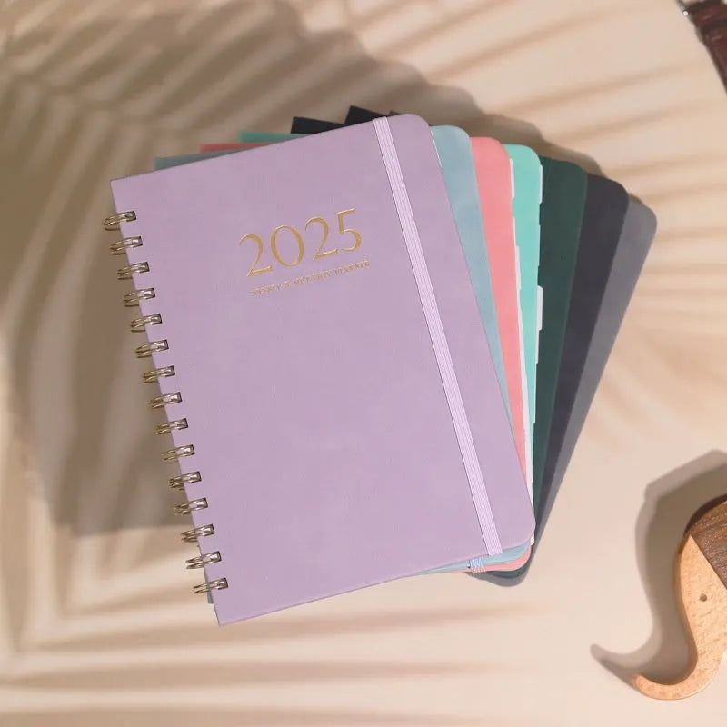 A5 size PU leather notebook with metal coil binding in a choice of colours including black, blue, brown, and pink.