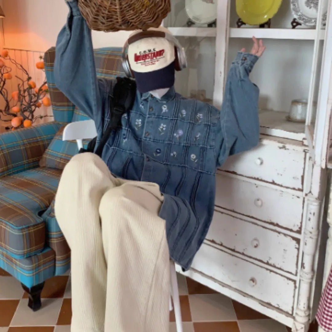 Washed blue denim shirt with small floral pleated detailing and button front closure