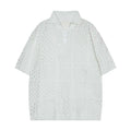 Black and white loose-fit cardigan-style short-sleeved polo shirt for teenagers on a hanger.