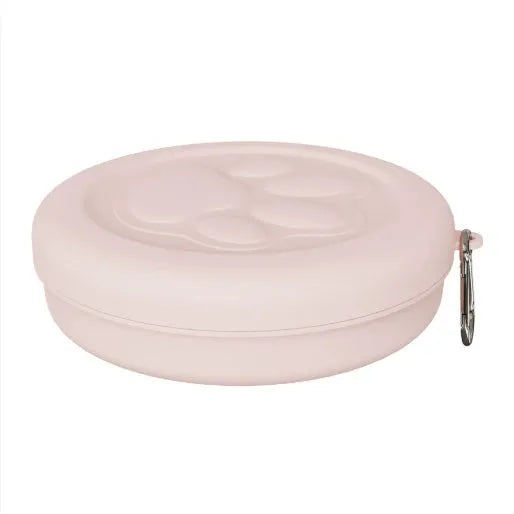Portable dog bowl in light green colour shown on grass for outdoor feeding