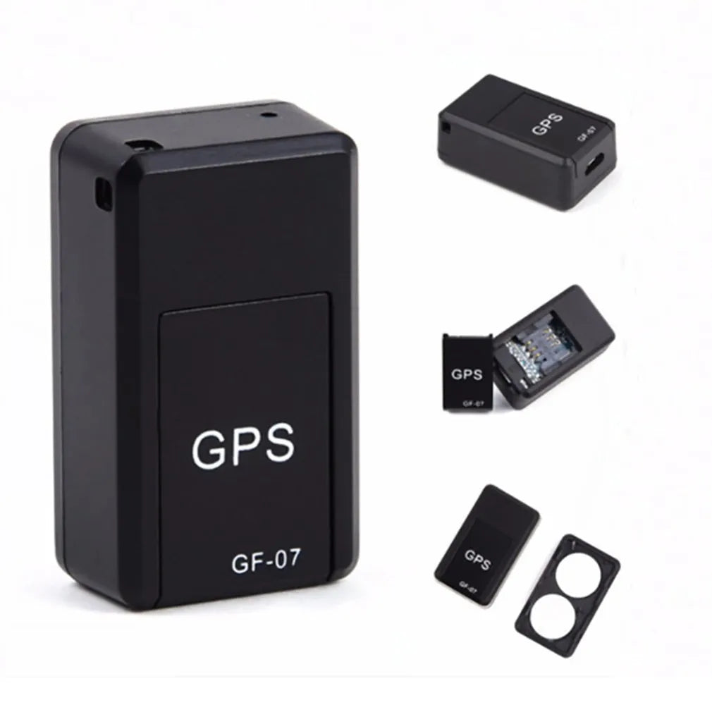 Black mini magnetic GPS tracker next to USB charging cable on a dark surface.