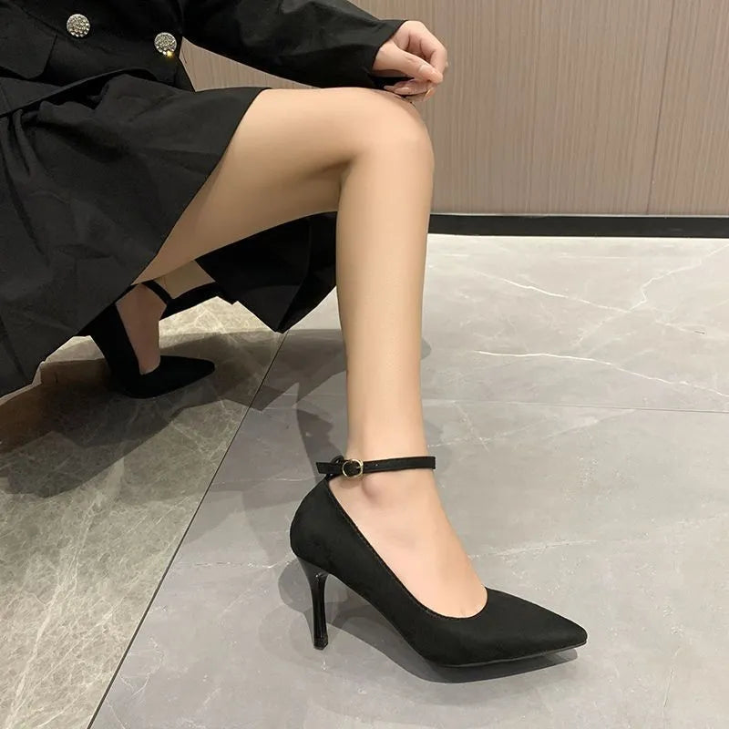 Women's black stiletto heel pump shoes with a buckle and skull pattern lining on a white background.