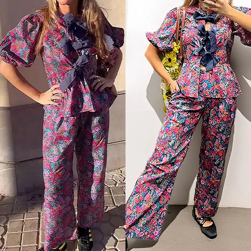 Women's floral print trousers suit with tie-neck blouse featuring puff sleeves and matching long trousers