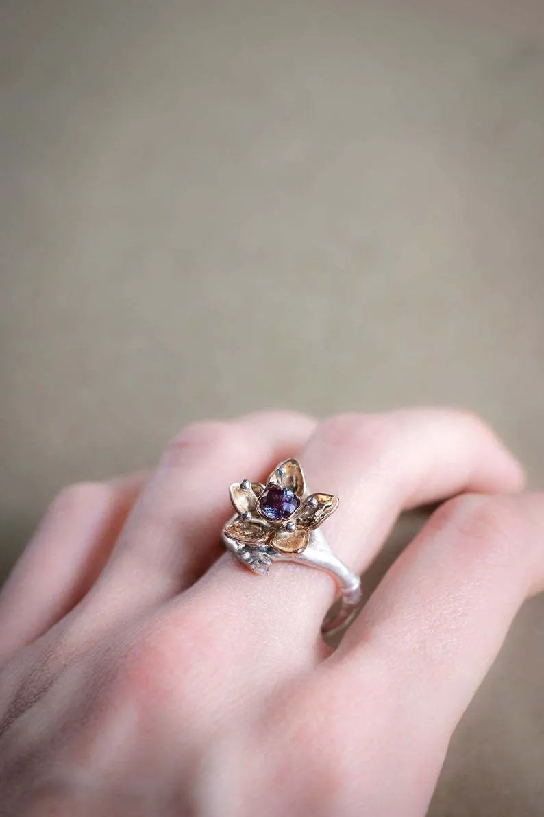 Two-tone silver alloy women's ring with floral geometric design on a flat surface