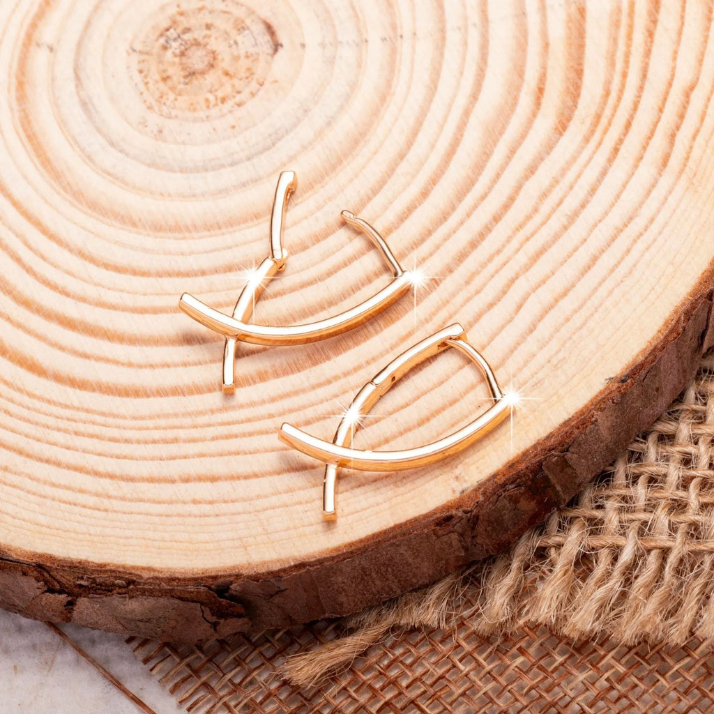 Rose gold cross shaped earrings with copper construction and light luxury aesthetic