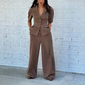 Brown slim fit two-piece polyester suit on a hanger, showing the long sleeve top and trousers.