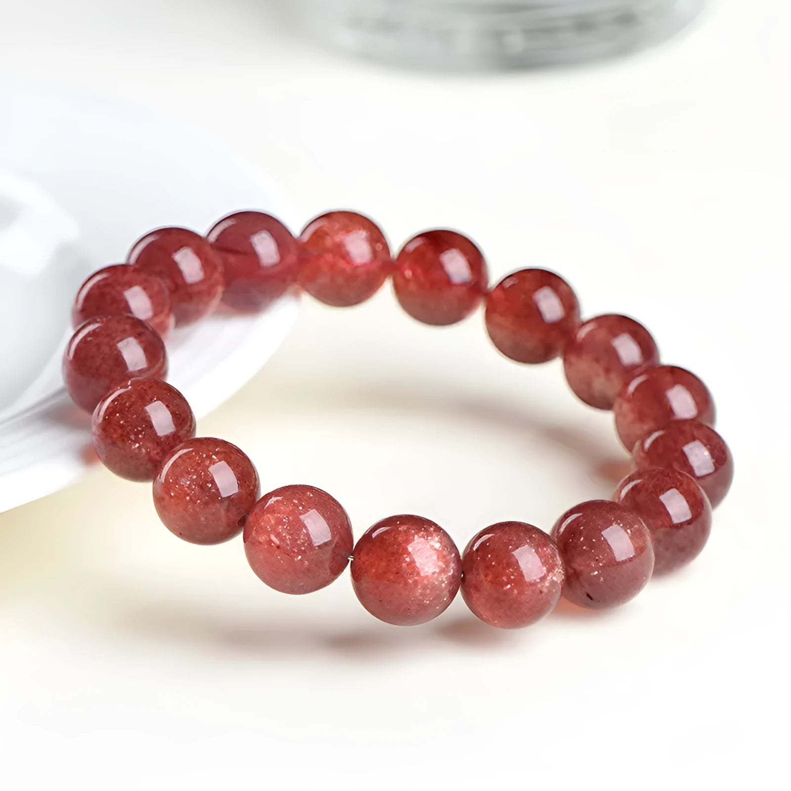 Natural strawberry quartz bracelet with geometric cherry red beads showing a starlight sparkle.