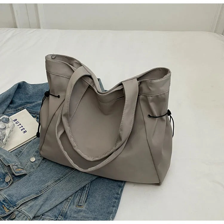 Soft Oxford cloth foldable tote bag shown in one of five colours: black, brown, dark grey, light grey, or purple.