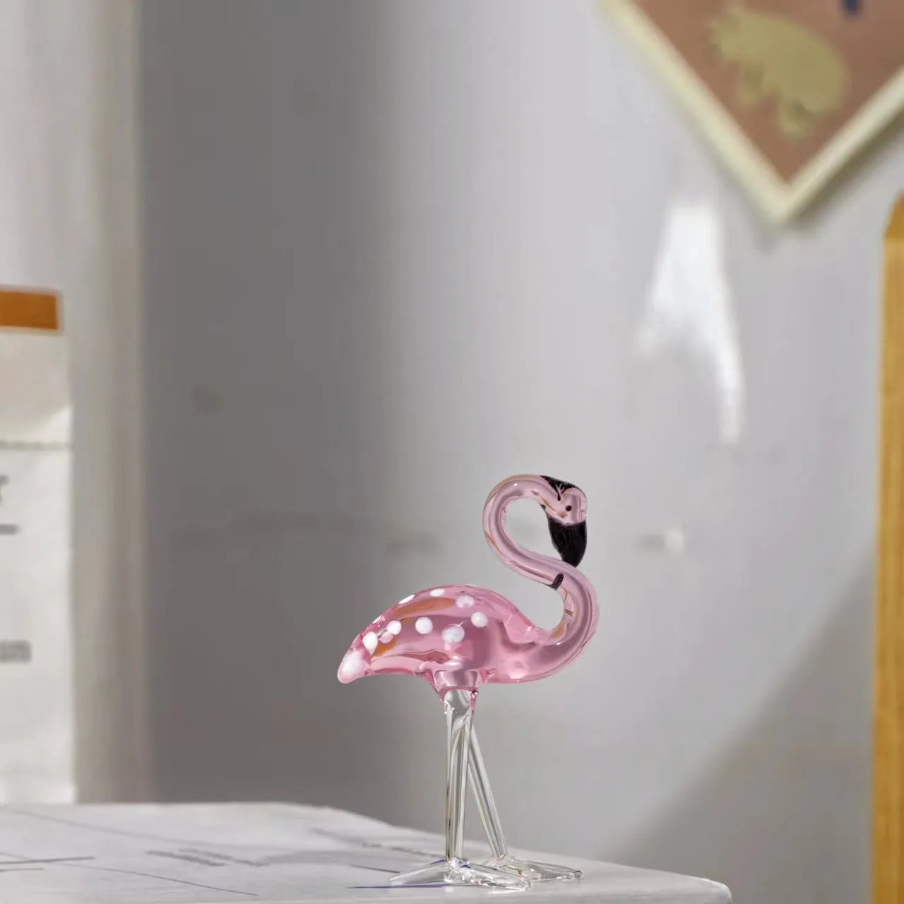 Pink flamingo crystal animal decoration on a tabletop in separate and juxtaposition styles.