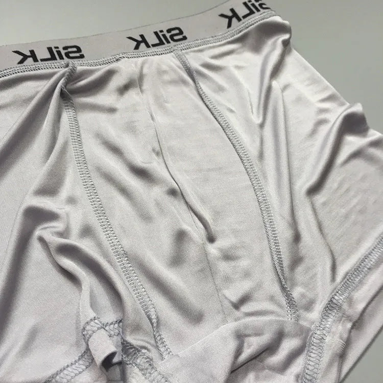 Men's loose fit silk shorts in navy blue on a neutral background