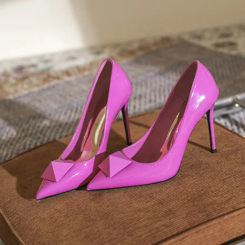 Women's pink patent leather pointed toe stiletto heels with buckle detail and super high heel
