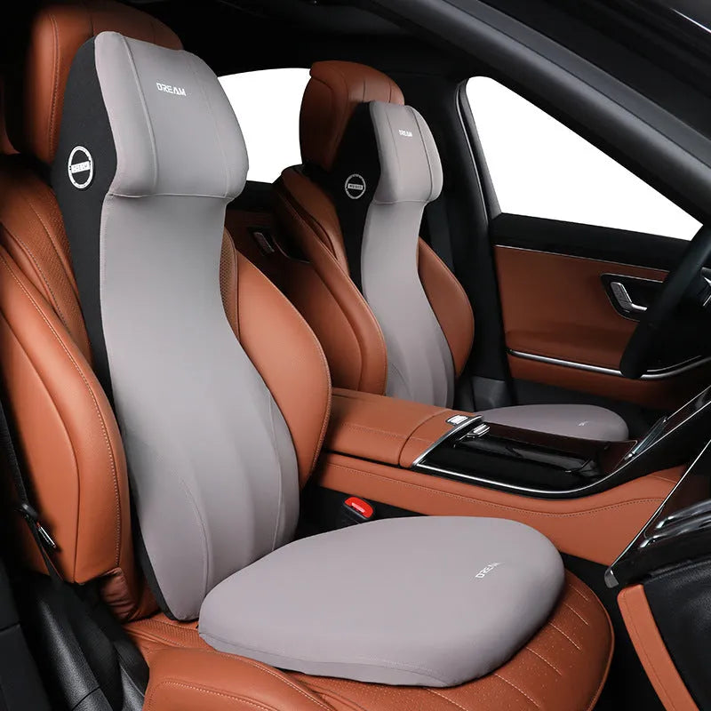 Black automotive memory foam cushion and headrest lumbar support pillow set on a car seat.