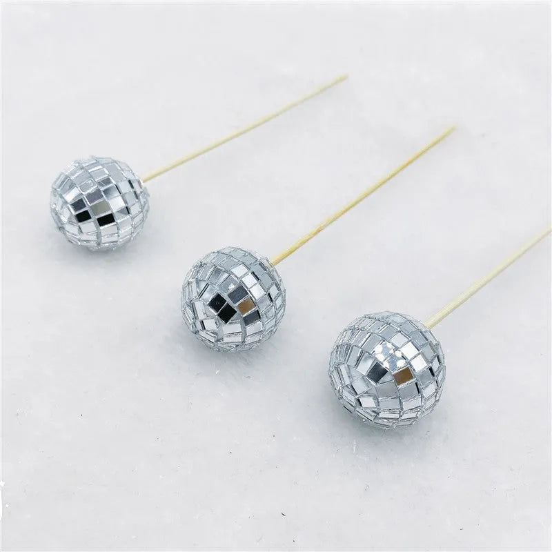 Glass disco ball cake decoration with wooden stick on a birthday cake