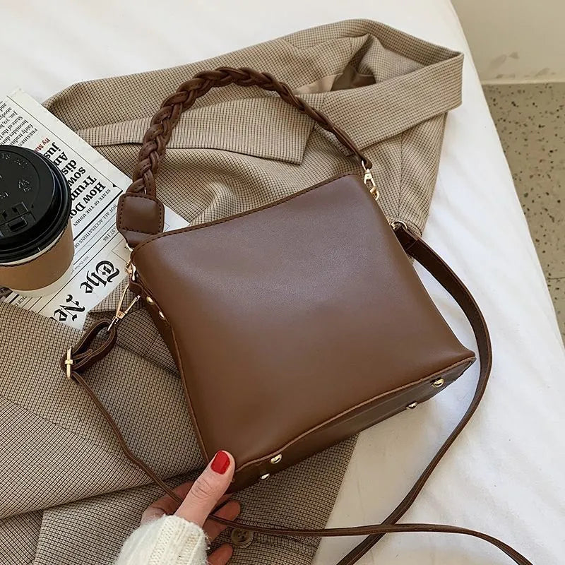 Unisex one-shoulder crossbody bucket bag in woven PU leather, shown in khaki colour.
