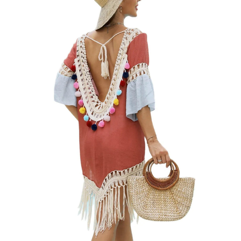 Orange floral beach overskirt with hand crochet detail and tassels, laid flat.