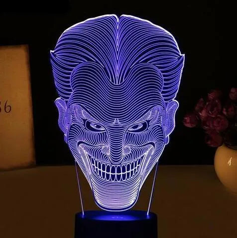 A 3D acrylic LED lamp displaying a gradient of colours, sitting on a square base with a USB cable.