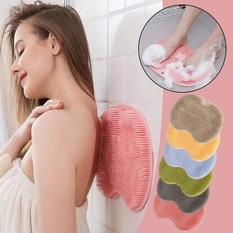 Orange silicone bath massage brush with suction cups on a bathroom tile floor.