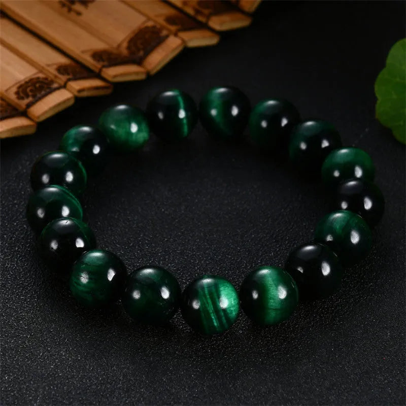 Green polished Tiger Eye stone bracelet with geometry beads on a wrist.